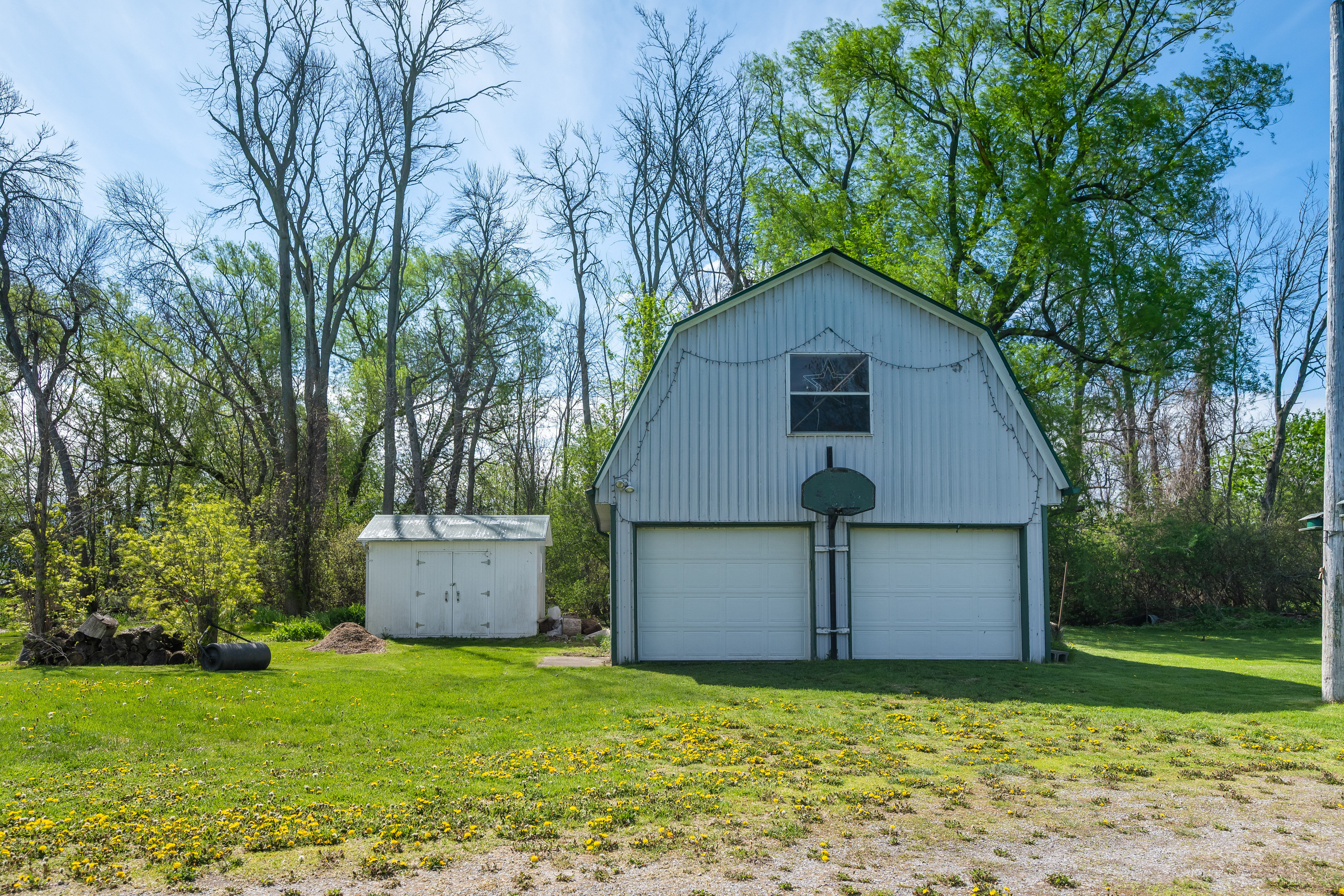 Barn and storage shed among mature trees