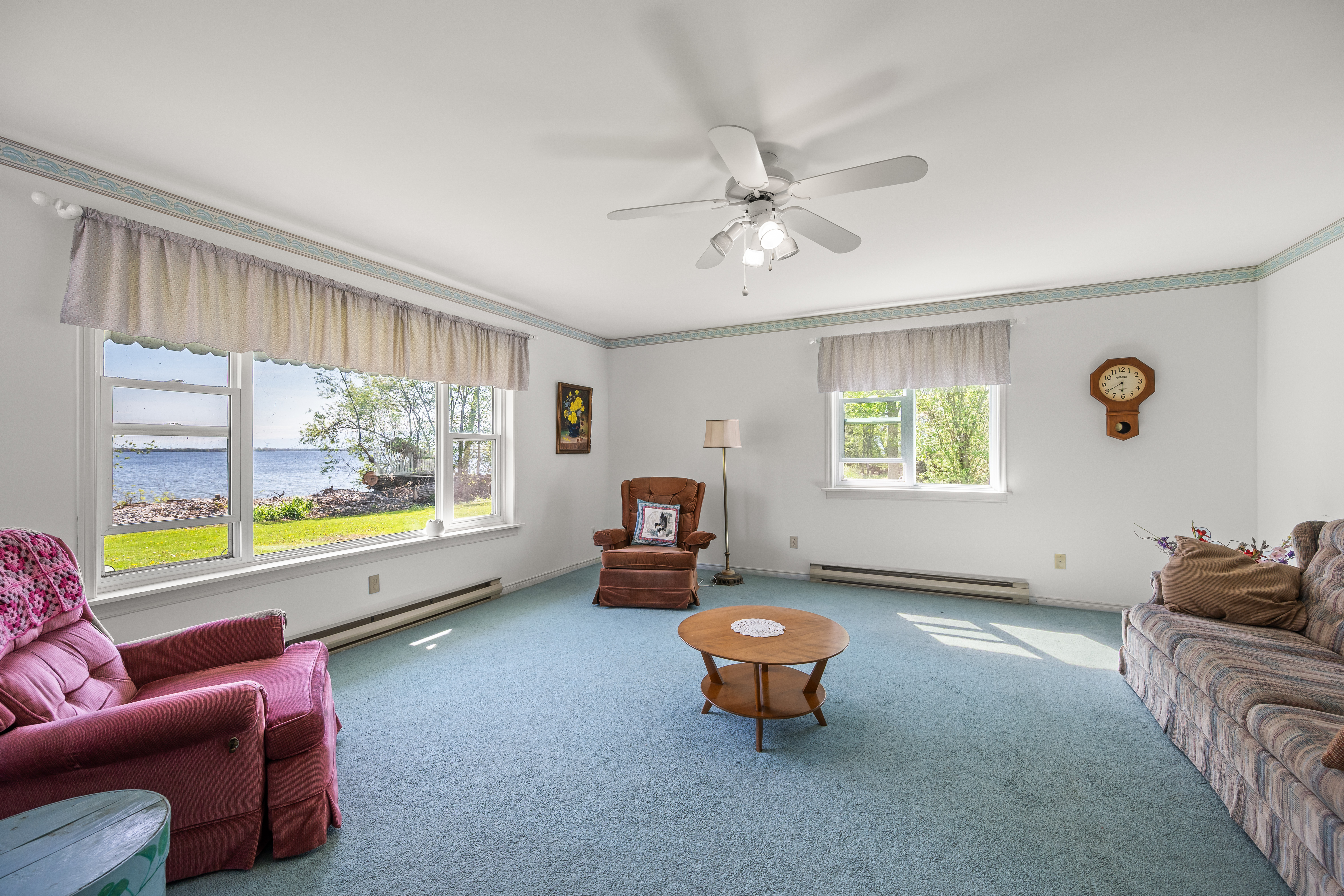 Waterside living room with a large window framing Lake Ontario