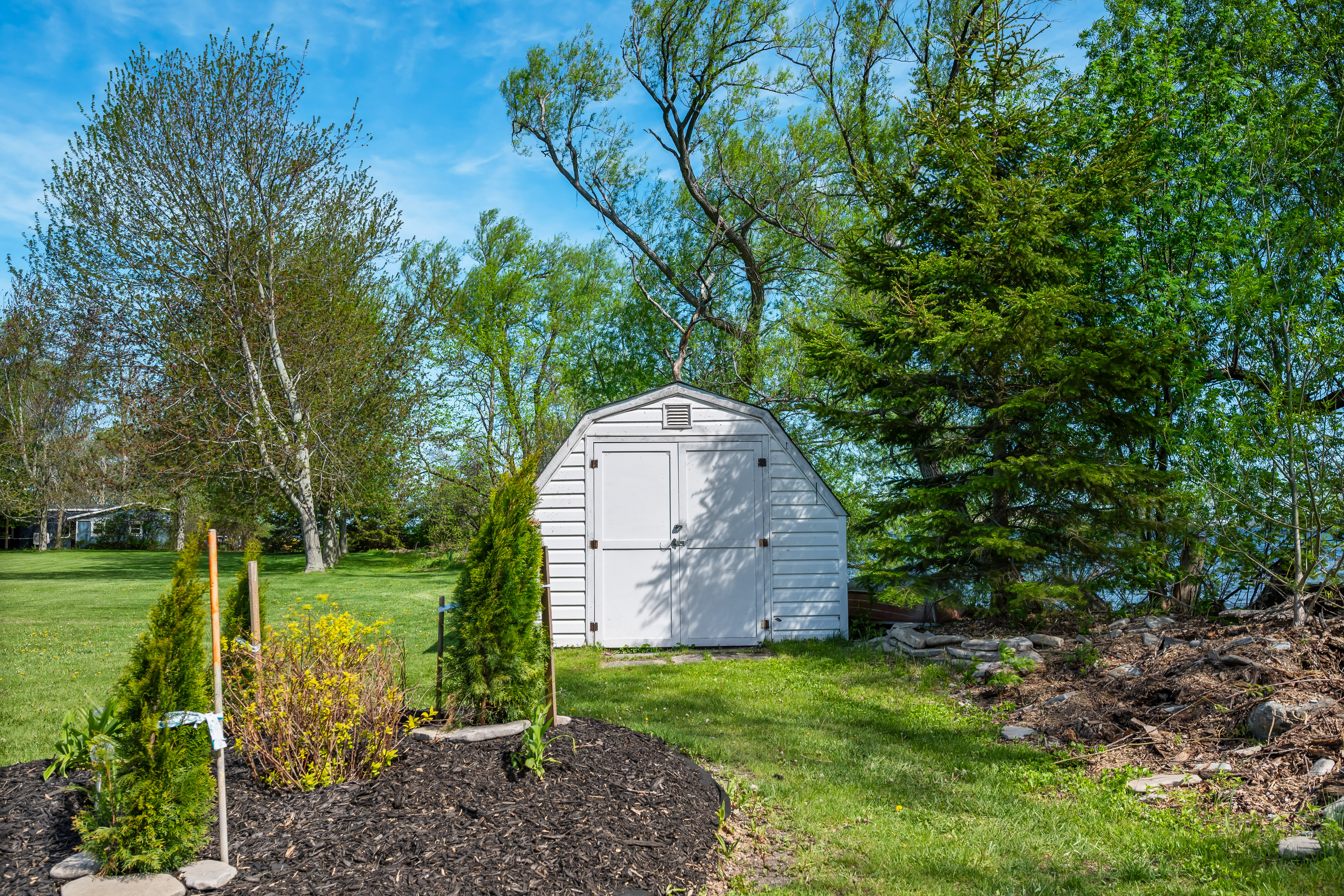 Garden shed by the waterfront with mature trees